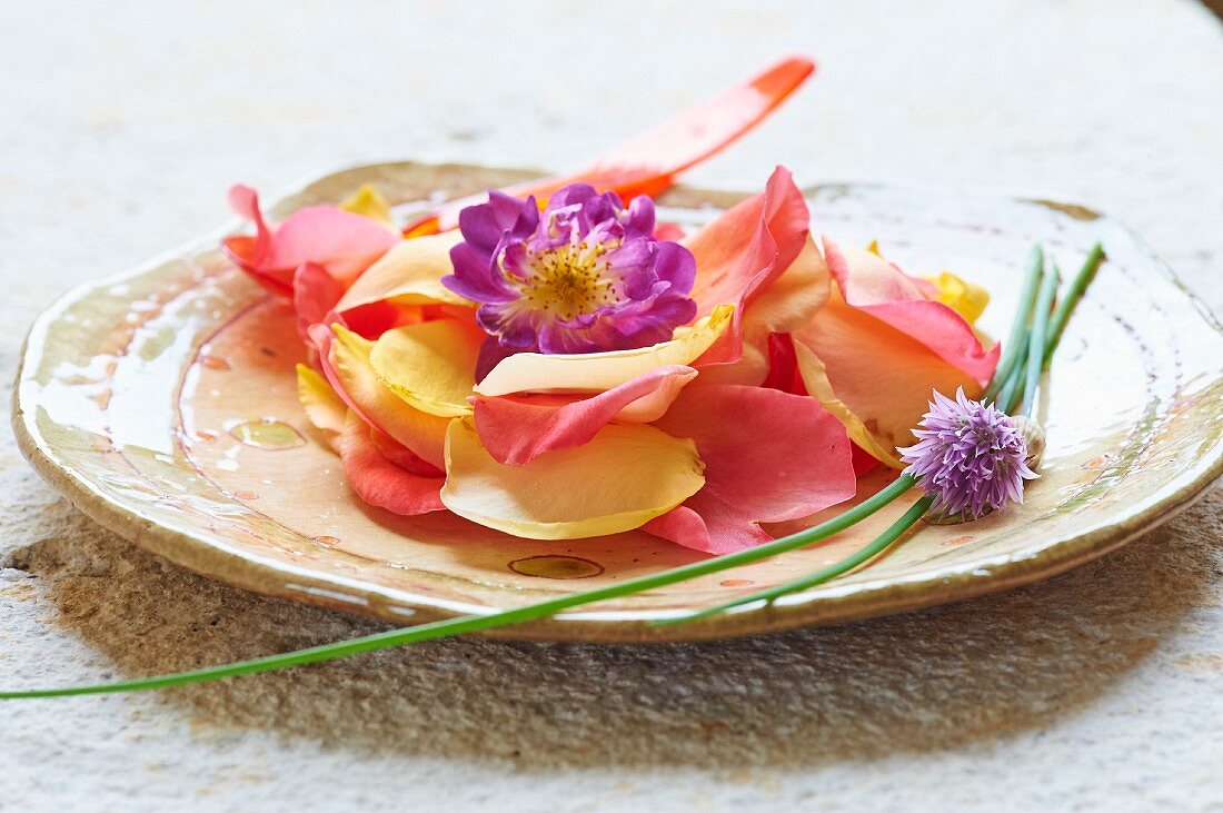 Delicate petals and chive blossoms on a plate