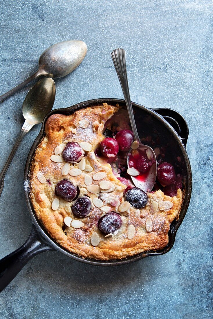Cherry clafoutis with almonds on a dutch pan