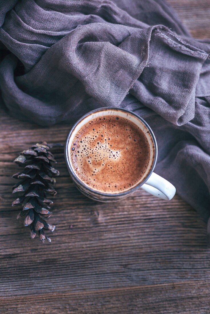 Eine Tasse Kaffee auf rustikalem Holztisch