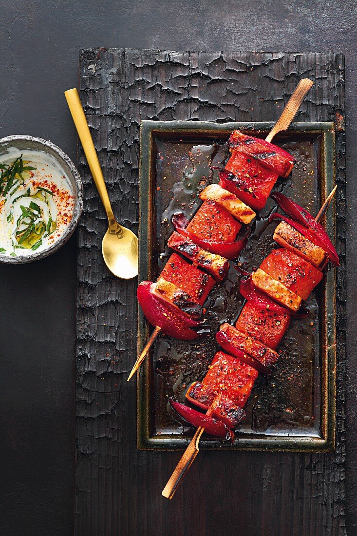 Grilled melon shashlik skewers with marinated pork belly and yoghurt and mint sauce