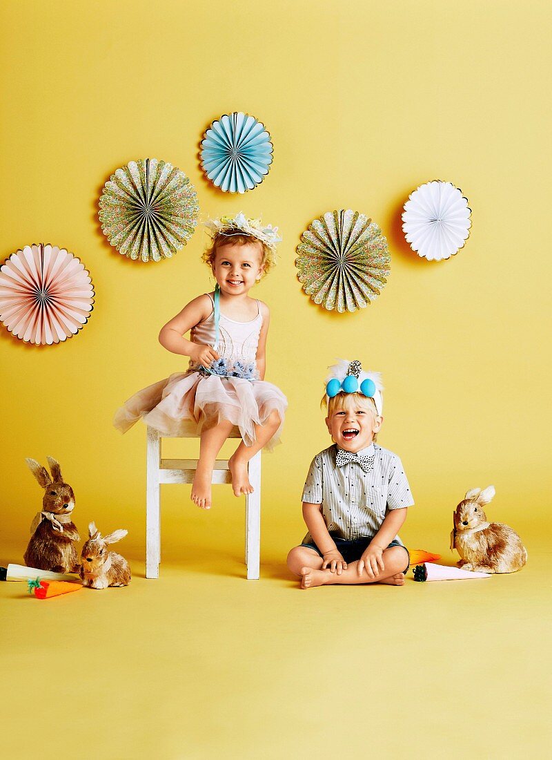 Two happy children with tinkered Easter crowns