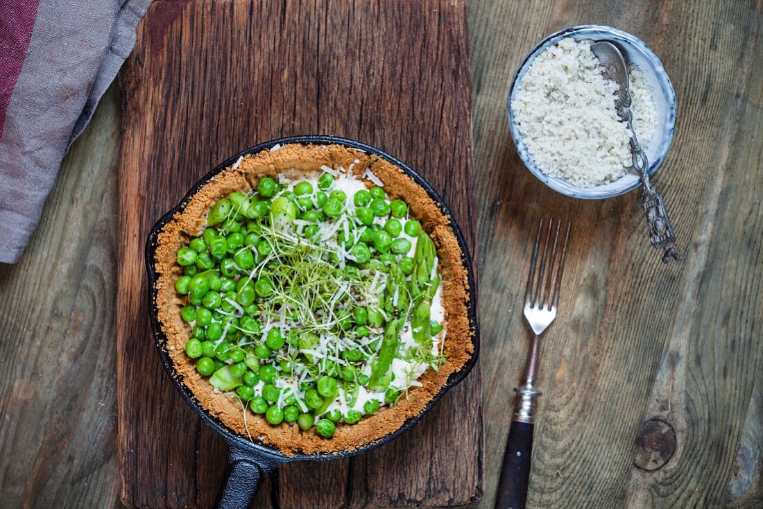 A flour-free spring tart with steamed asparagus, peas, goat's cheese, cress and Parmesan