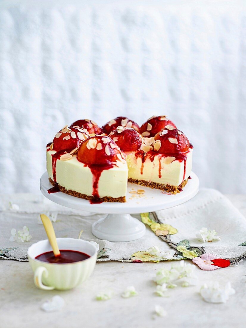 Cheesecake with peaches and raspberry sauce on cake stand