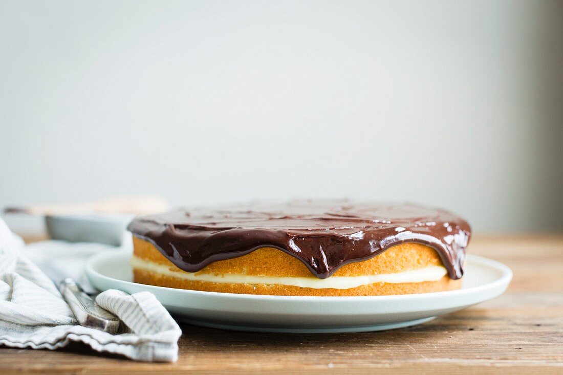 Vanilla layer cake with cream filling and chocolate sauce topping