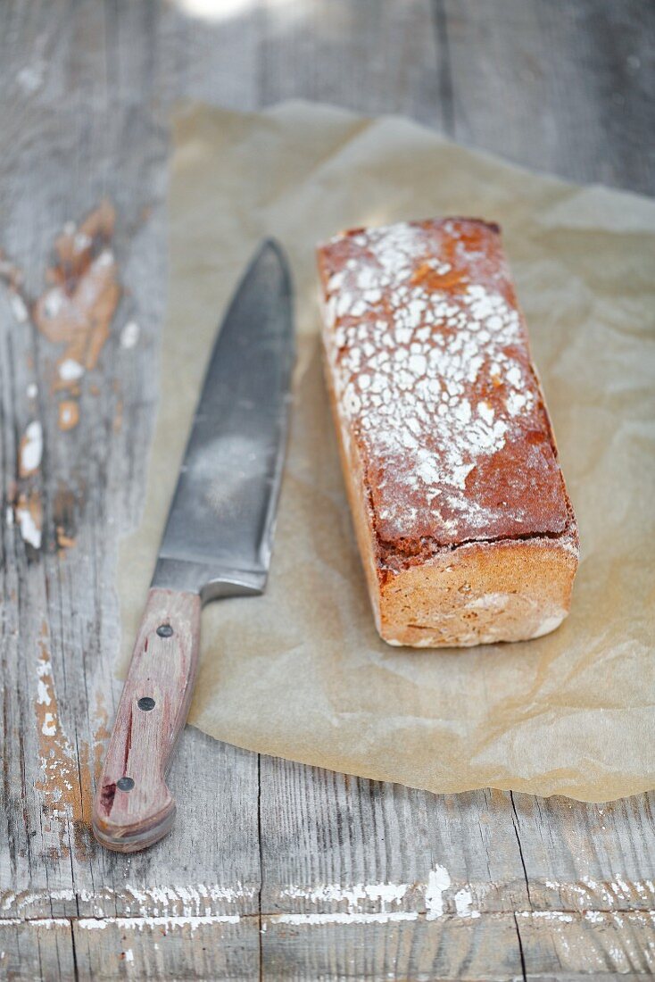 Vollkornbrot auf Papier mit Messer