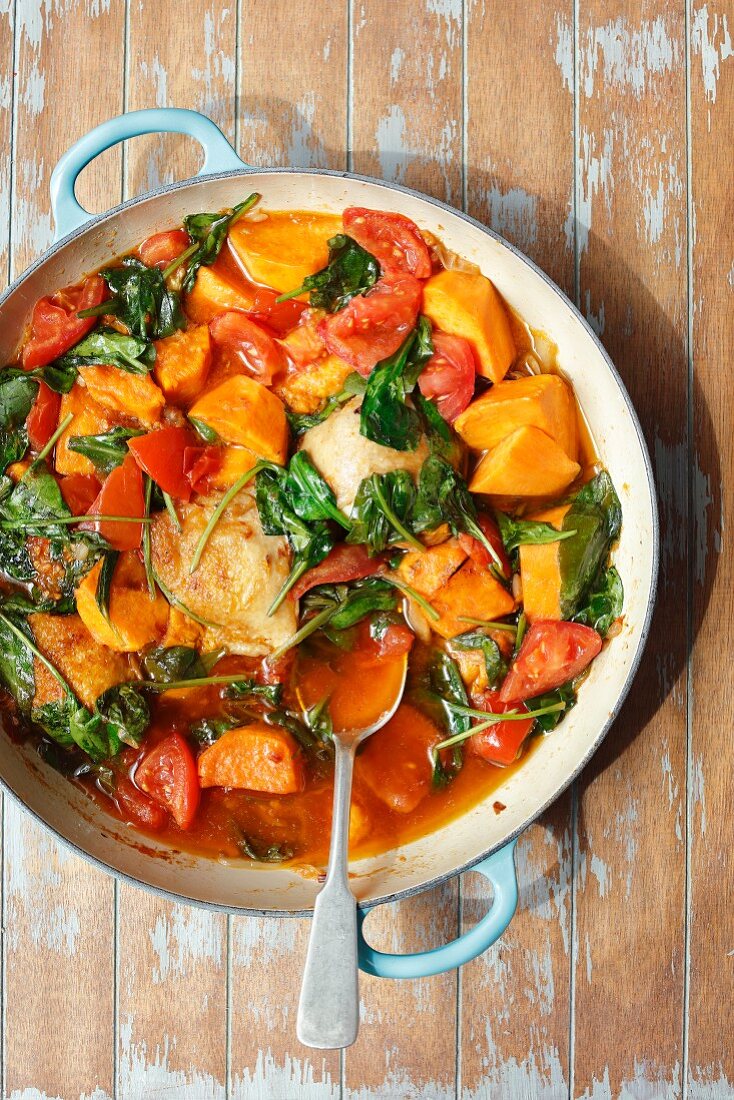 Chicken thights braised with sweet potatoes, spinach and tomatoes