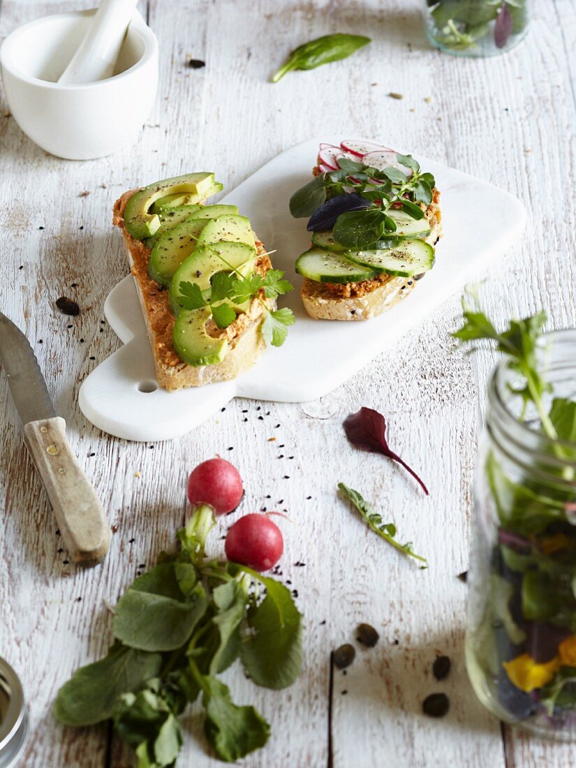 Open sandwiches with avocado, cucumber slices and wild herbs