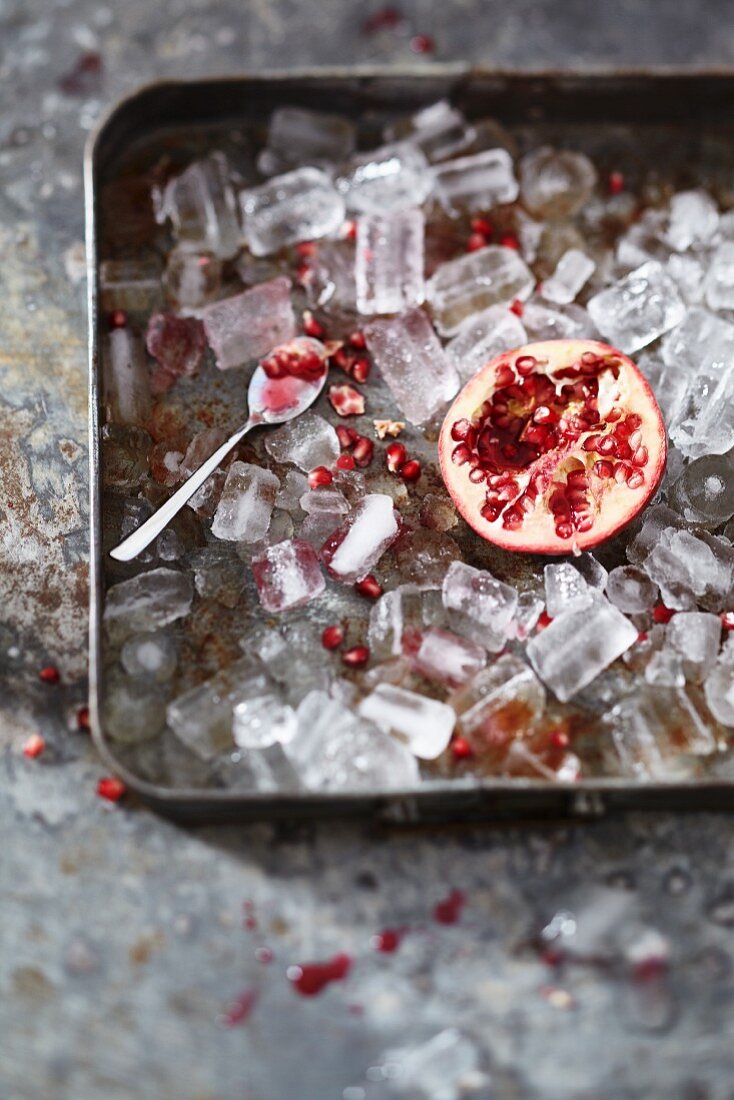 Half a pomegranate in a tray of ice cubes