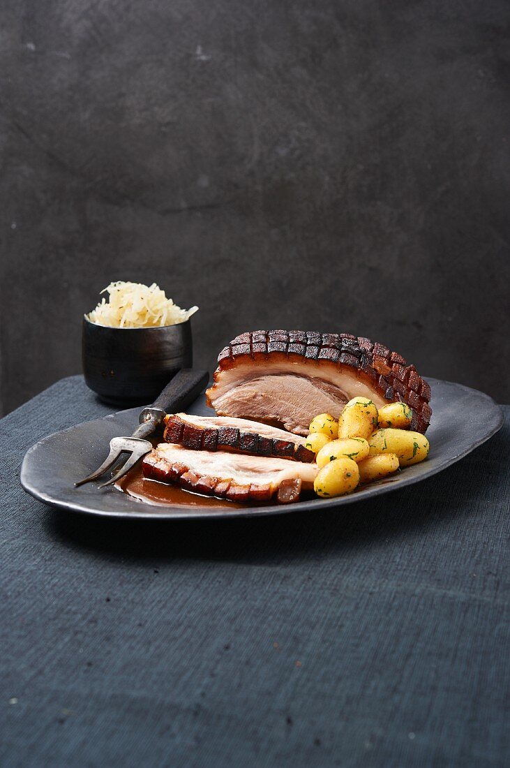 A joint of roast pork with potatoes and sauerkraut