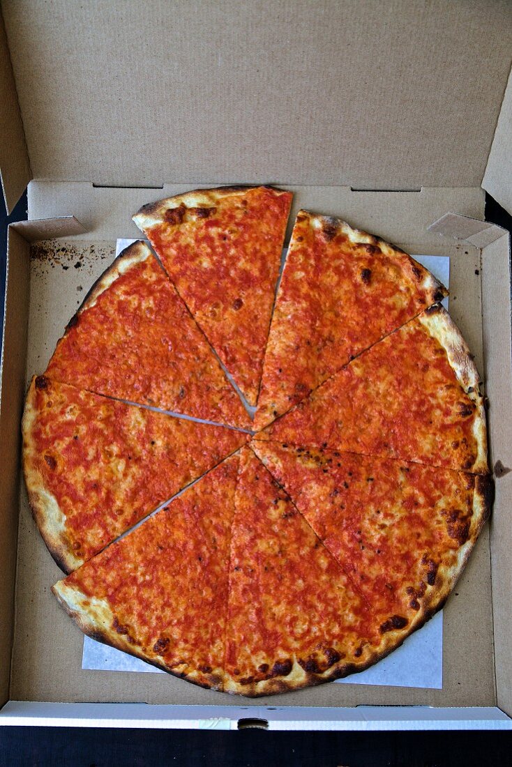 Eine Pizza in geöffnetem Pizzakarton (Aufsicht)