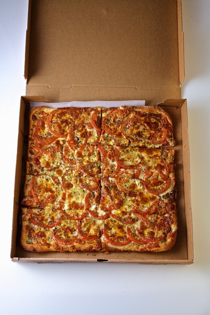 Tomatenpizza in geöffnetem Pizzakarton