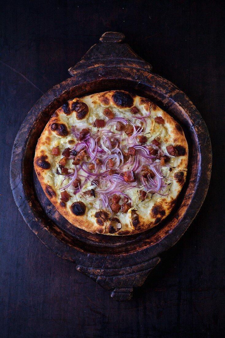 A tarte flambée with onion, bacon and crème fraîche (seen from above)