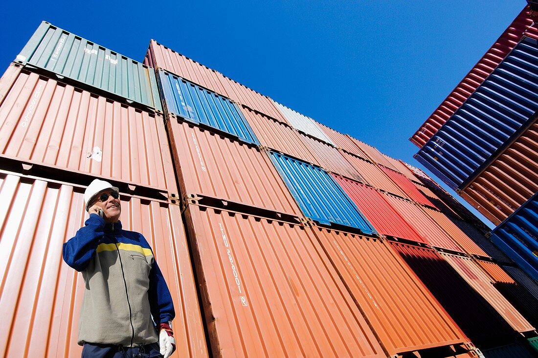 Man on cell phone with shipping containers