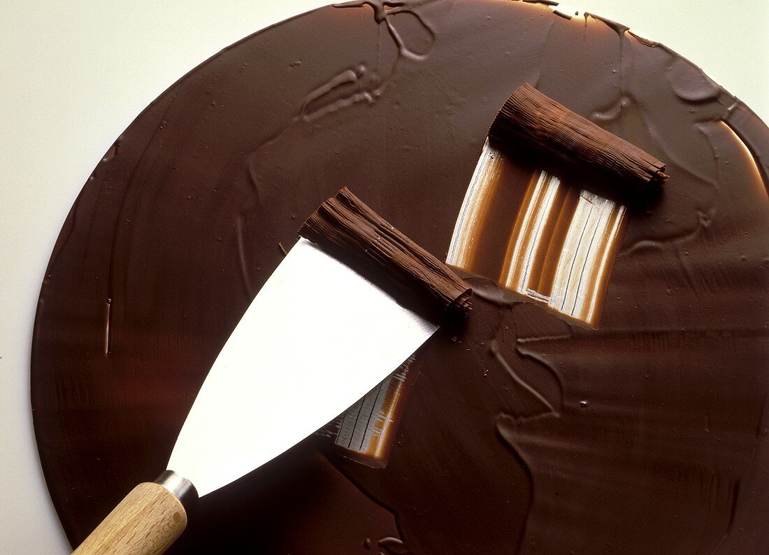 Schokoladenröllchen aus Kuvertüre vom Blech schaben
