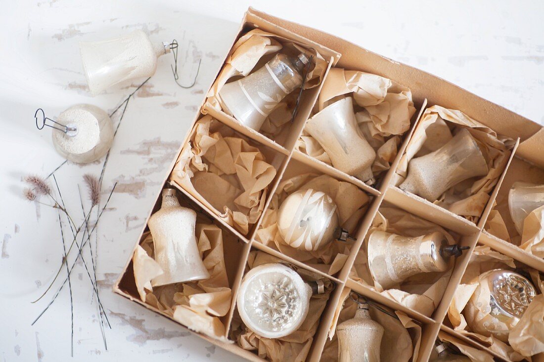 Vintage-style Christmas baubles in old cardboard box