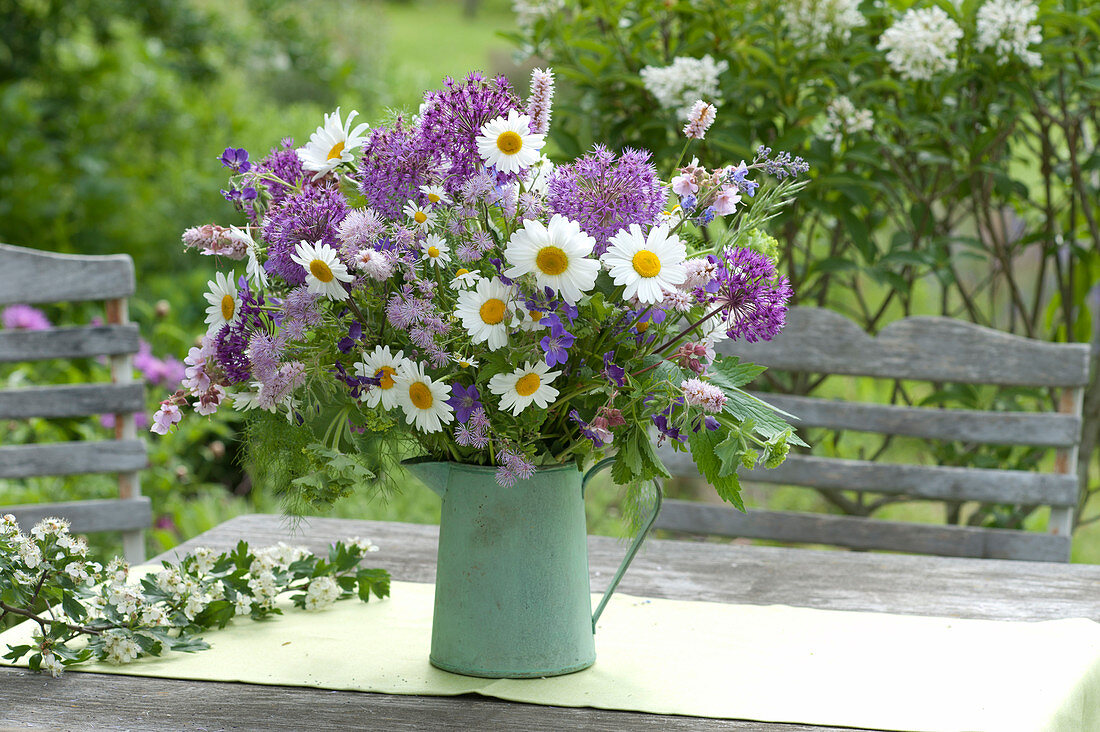 Early summer flowering perennials bouquet in a green pot