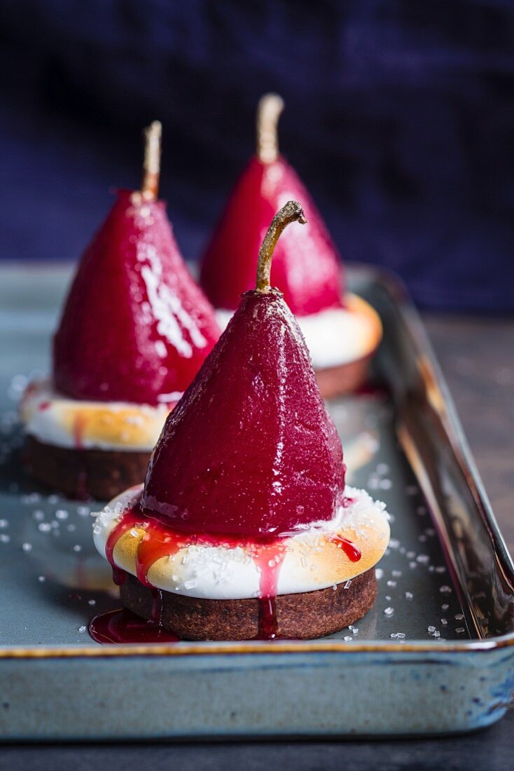 Desserts with red wine infused pears and meringue