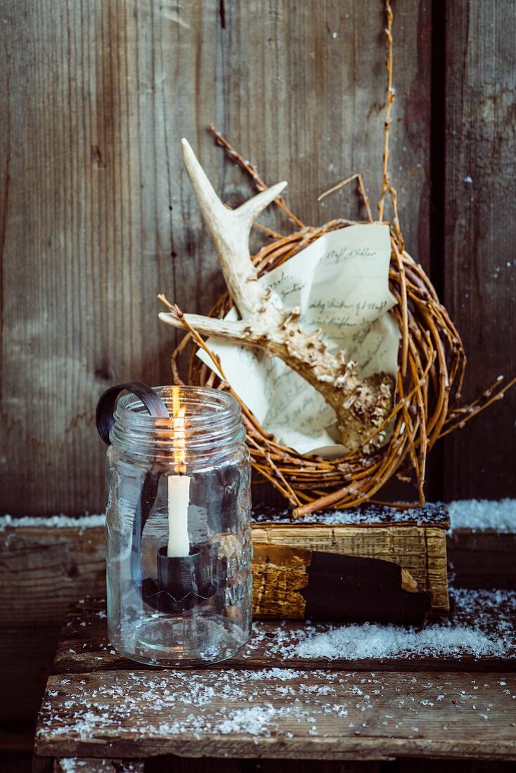 Rustic Christmas arrangement of willow wreath, antlers and candle