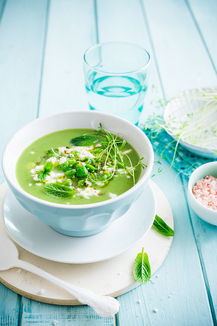 Pea and fava bean soup with beansprouts and mint leaves