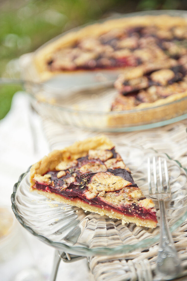 A slice of beetroot tart on a picnic basket