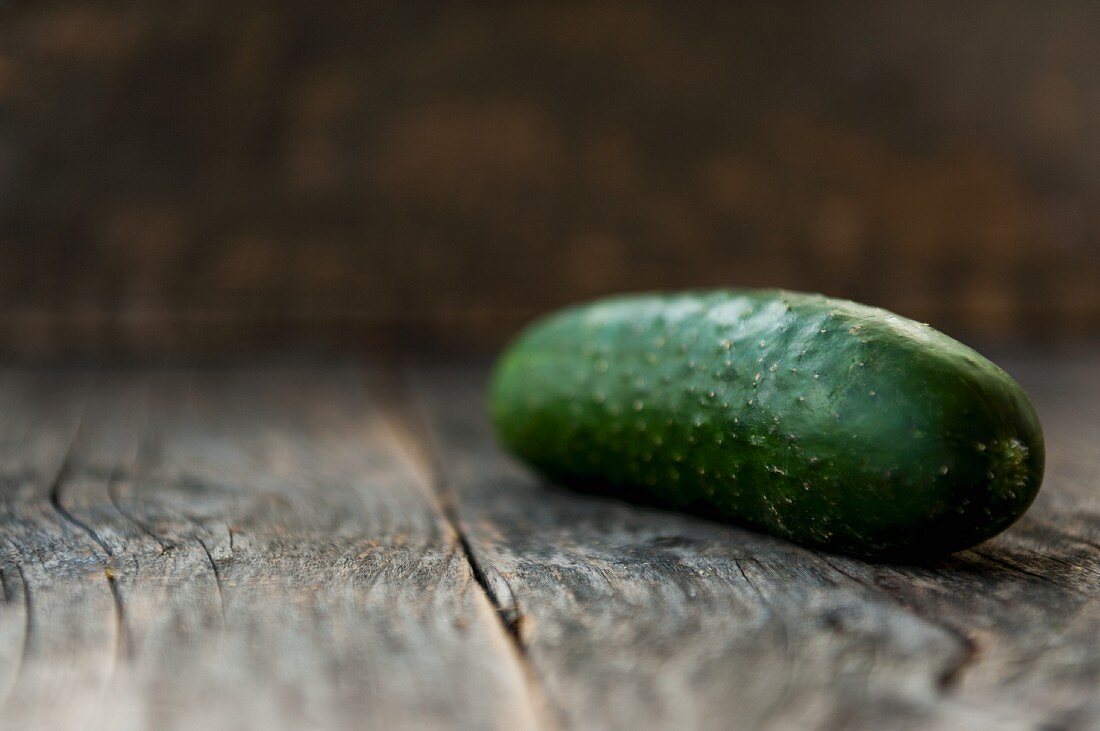 A cucumber on a wooden background (close up)