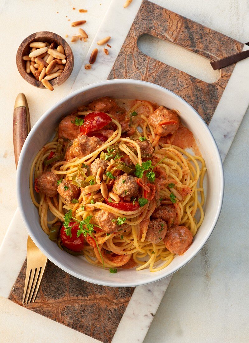 Hackbällchen auf Spaghetti mit Pinienkernen und Kirschtomaten