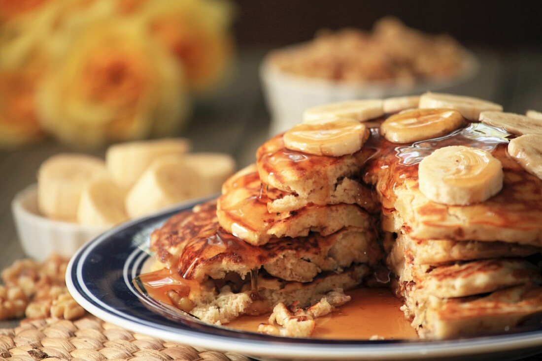 Pancakes mit Walnüssen und Bananen, gestapelt auf Teller