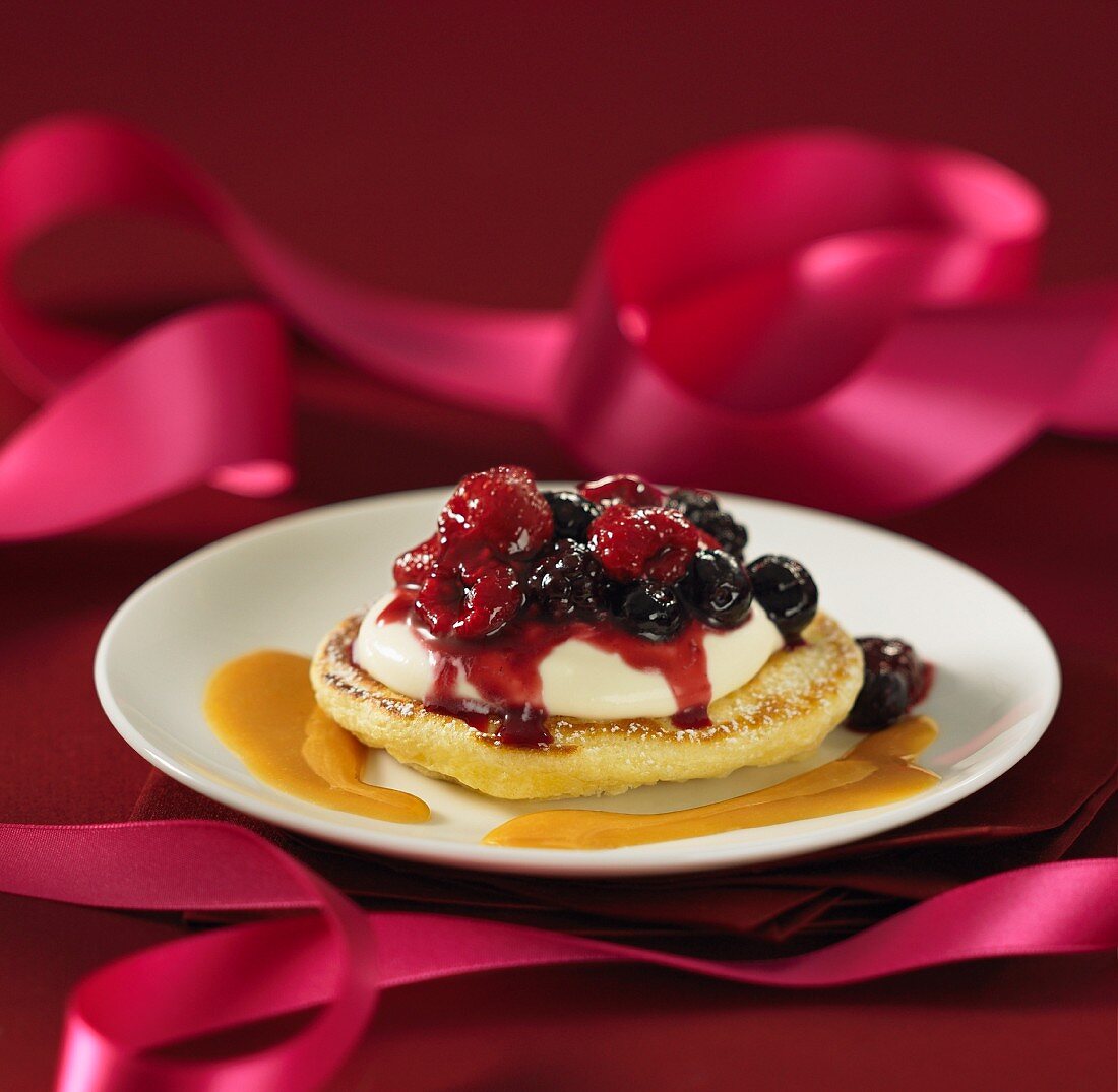 Blini topped with cream and berries