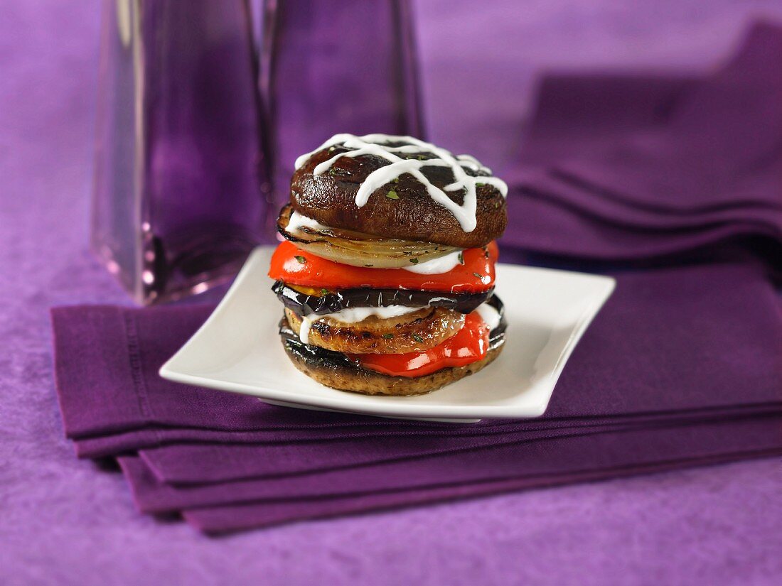 A tower of grilled portobello mushrooms, peppers and onions