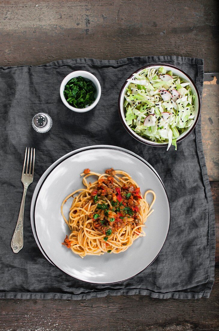 Spaghetti mit Linsenragout serviert mit Kohlsalat (vegan)