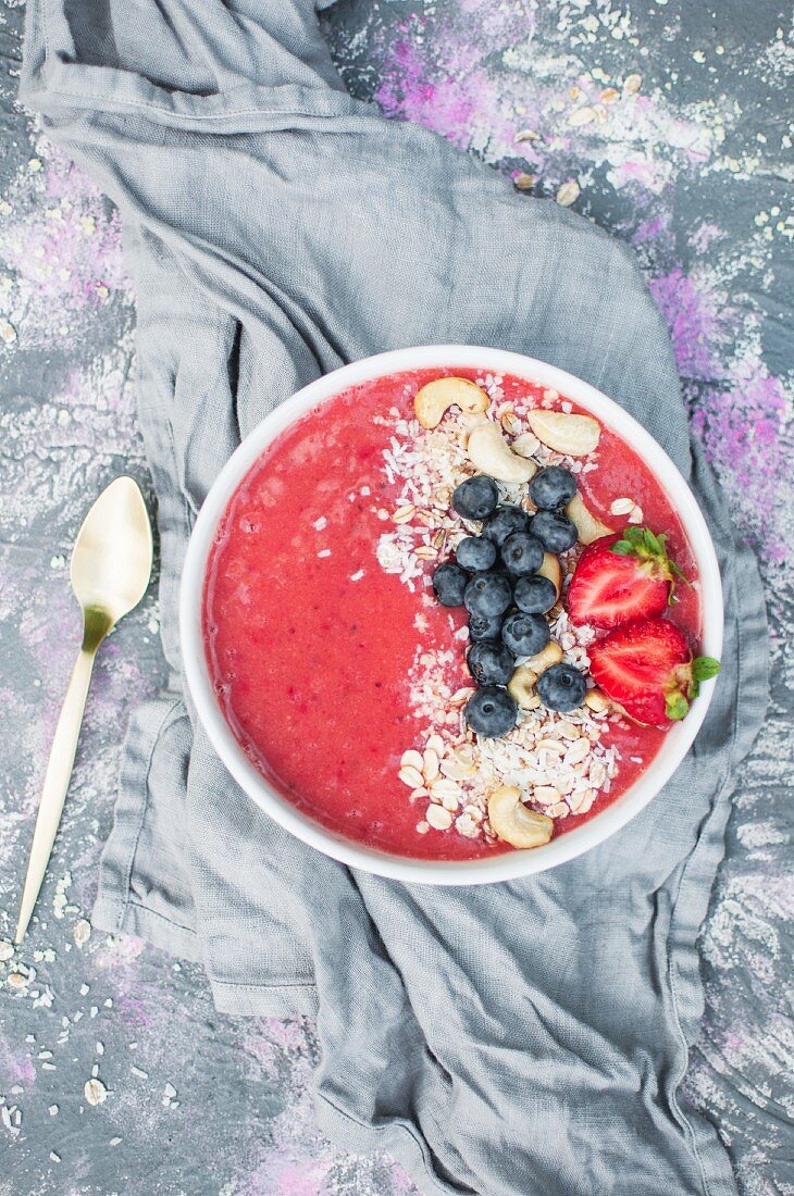 Erdbeer-Smoothie-Bowl mit Blaubeeren, Cashew und Getreideflocken