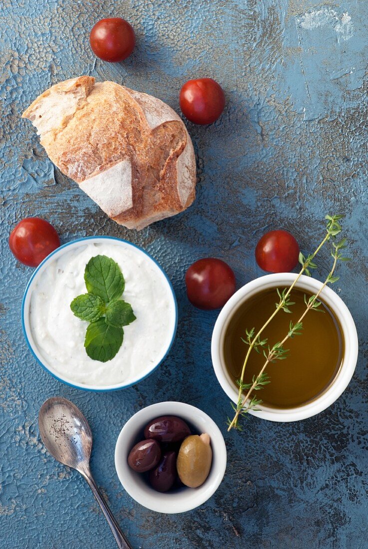 Tzatziki mit Brot, Oliven, Kirschtomaten und Olivenöl