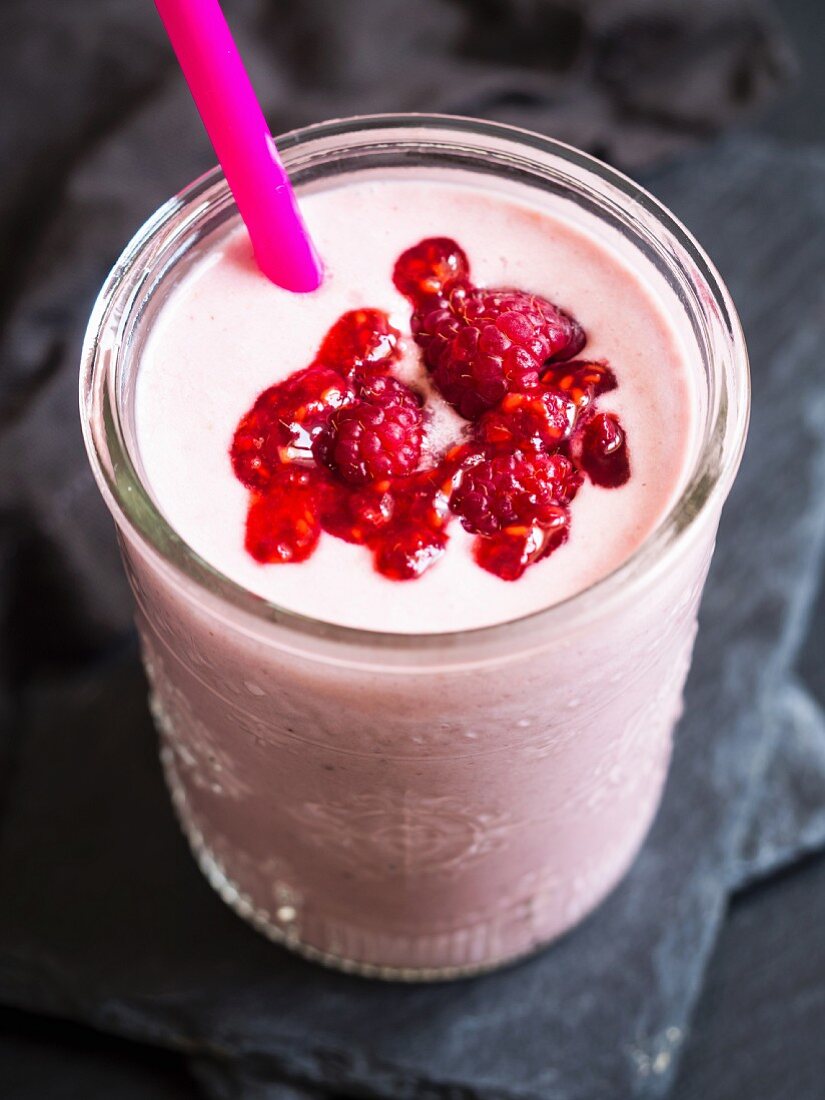 Roter veganer Smoothie mit Himbeeren im Glas