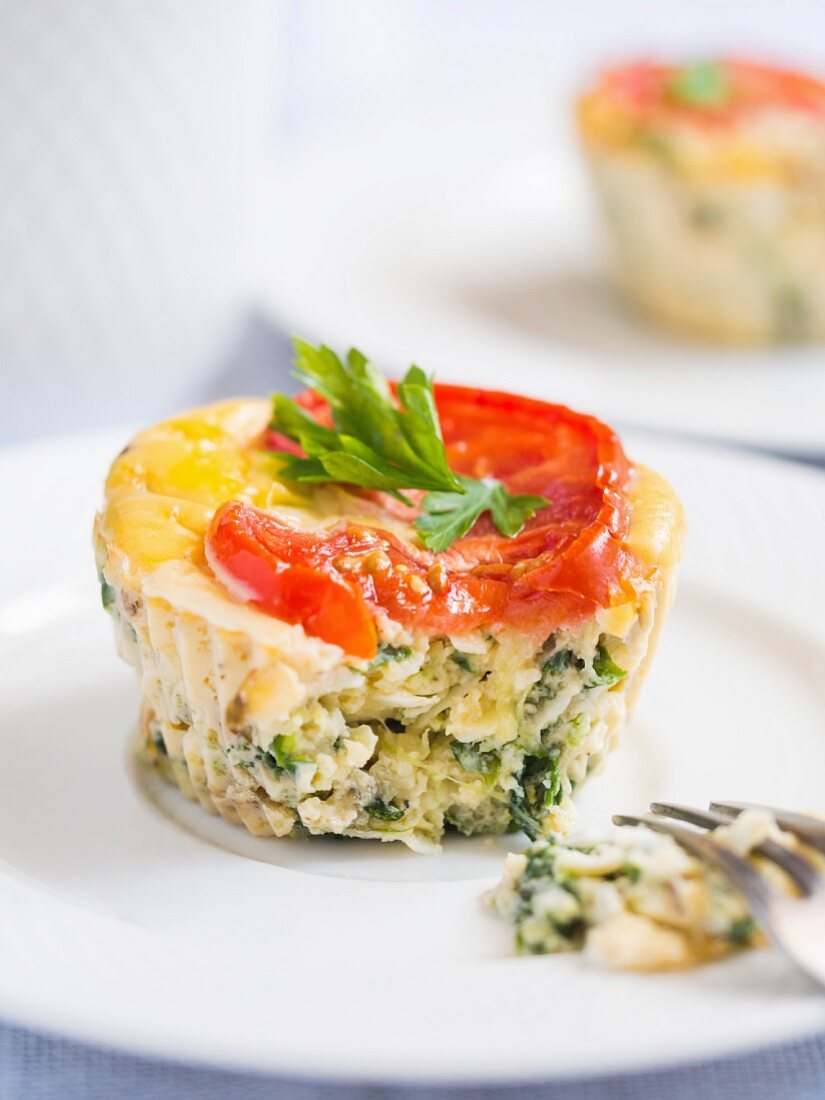 Breakfast egg muffins with spinach, zucchini and tomatoes, close up