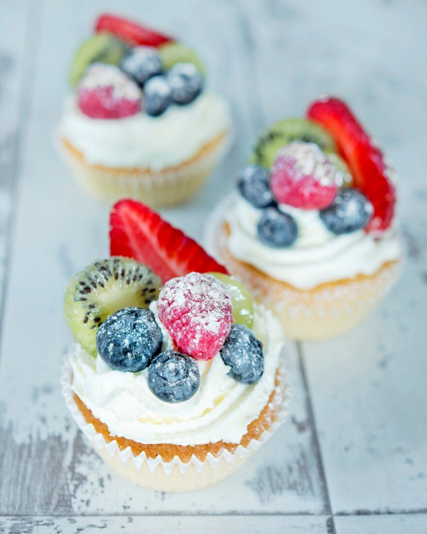 Sommerliche Cupcakes mit Sahnehäubchen und frischen Früchten