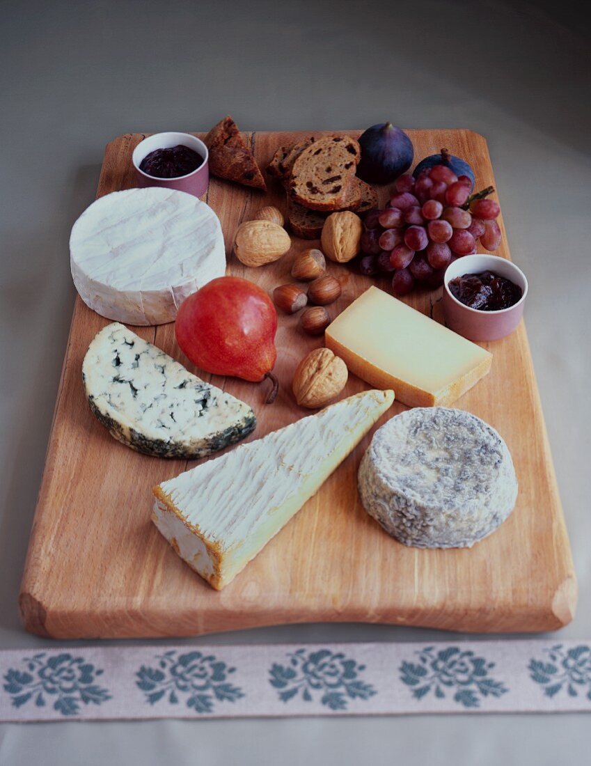 A cheese board with fruit, nuts and bread