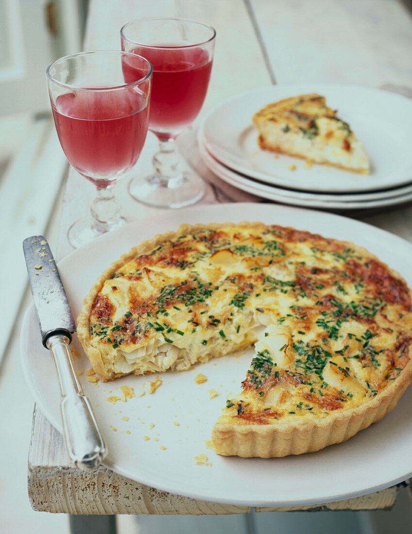 Quiche topped with herbs, sliced
