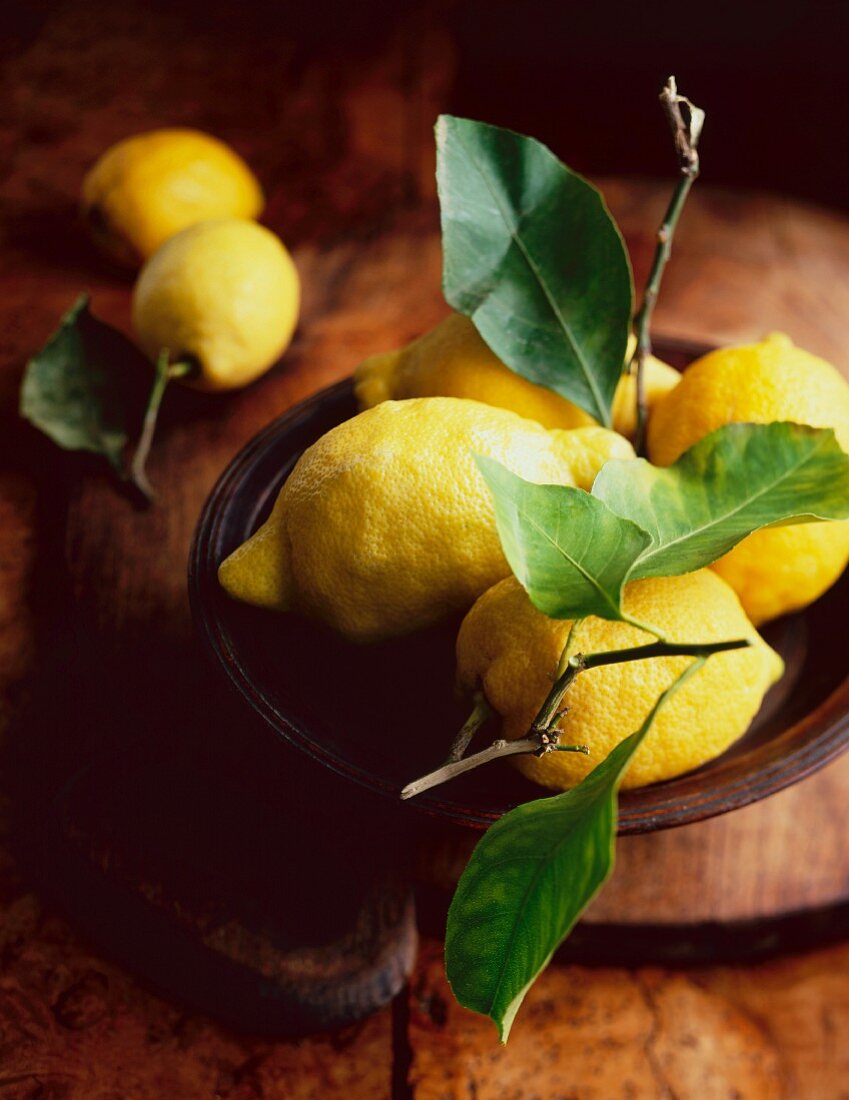 Lemons with leaves in a wooden bowl