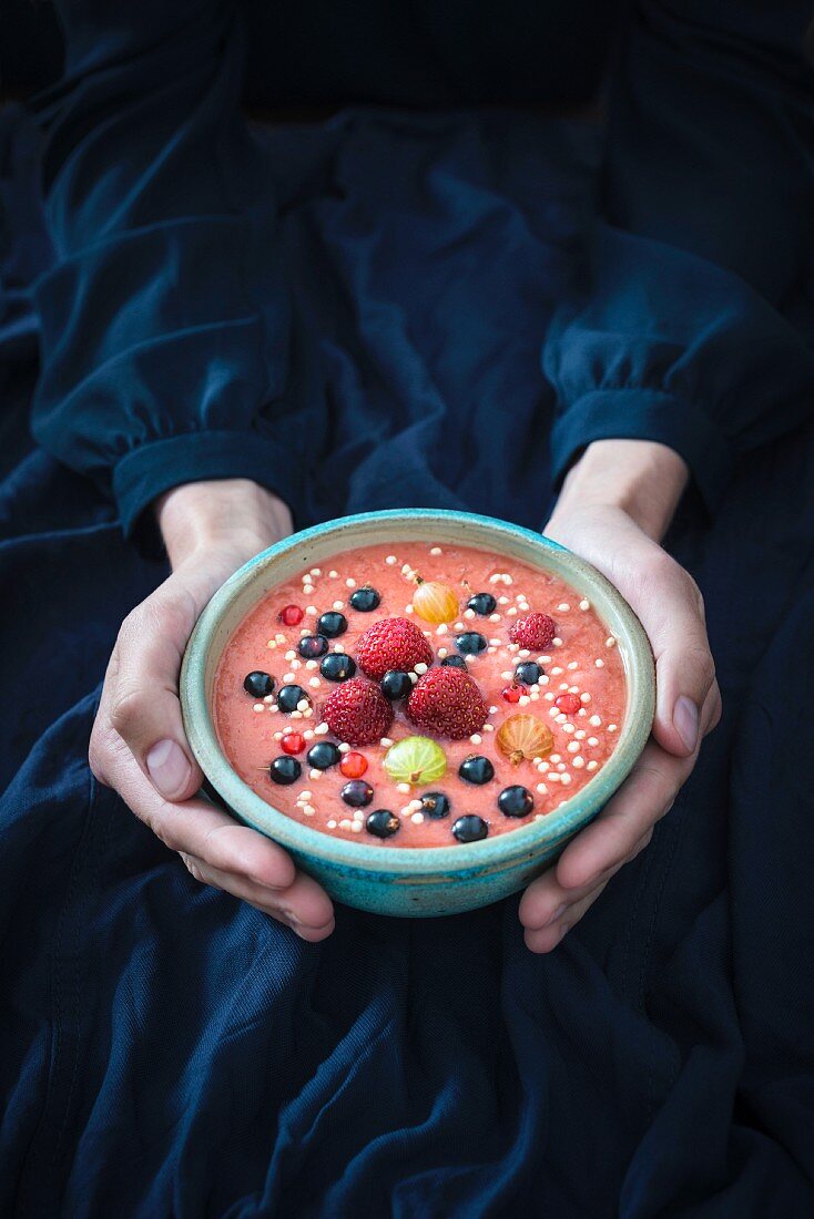 Frauenhände halten vegane Smoothie Bowl