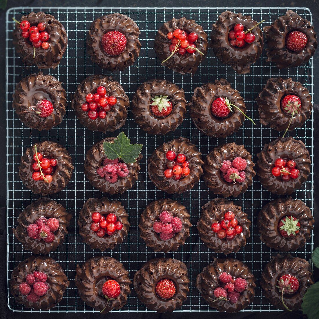 Vegane Mini-Schokoladen-Gugelhupfe mit verschiedenen roten Beeren