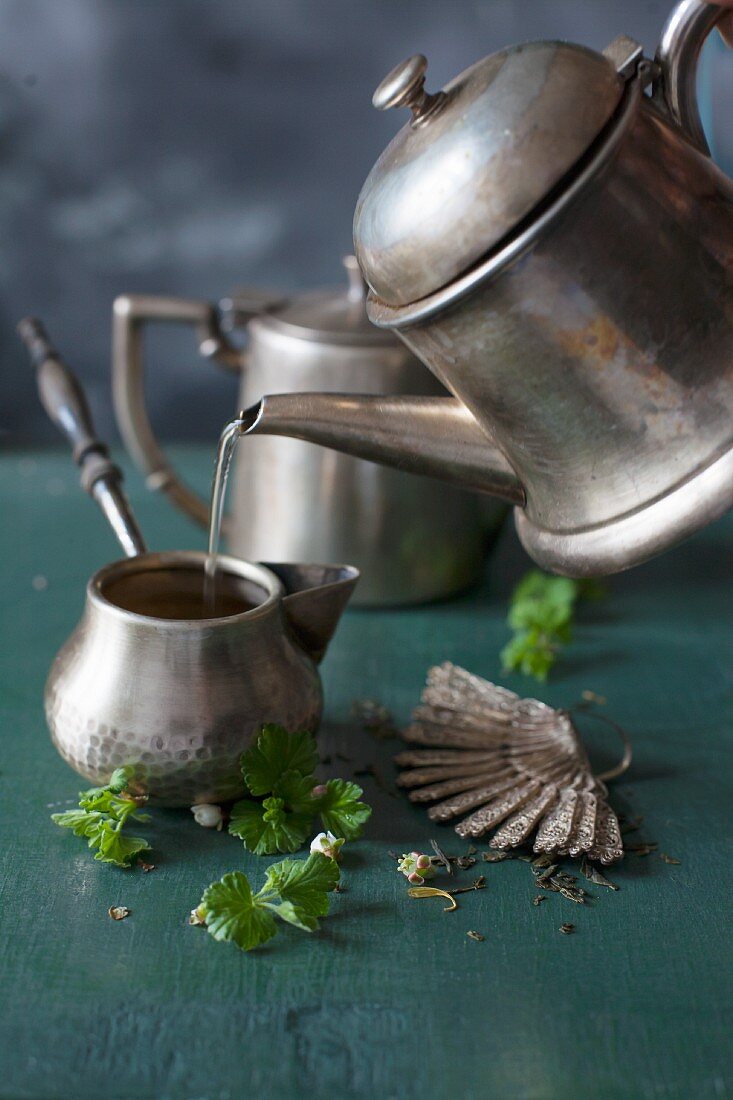 Teezubereitung in Silberkännchen