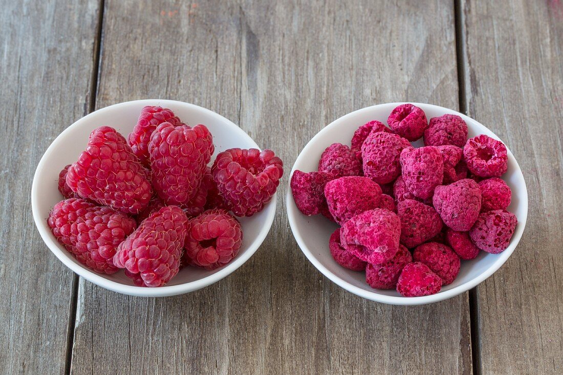 Fresh and freeze-dried raspberries in small bowls