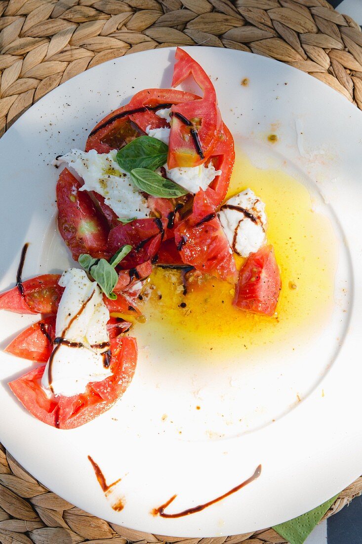 Tomaten mit Mozzarella auf Teller (Aufsicht)