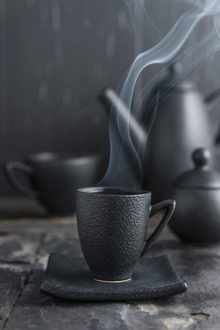 Steaming tea in a black cup
