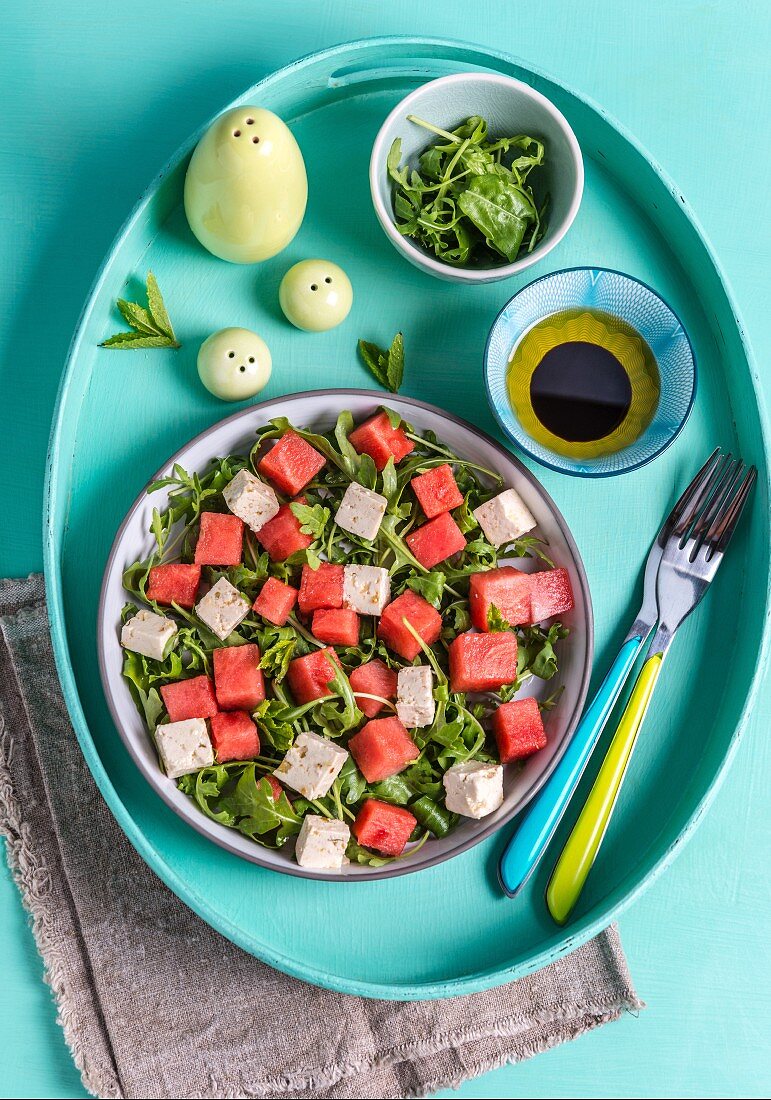 Vegan feta and watermelon salad with mint and rocket (top view)