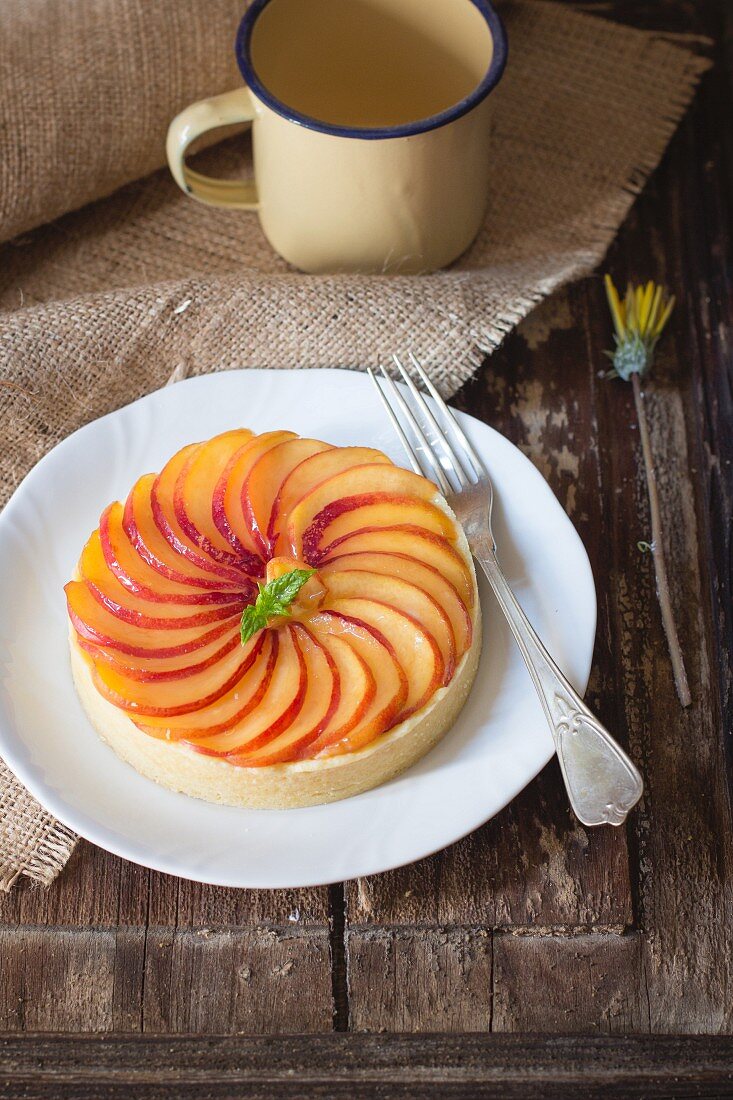 A peach tart on a white plate