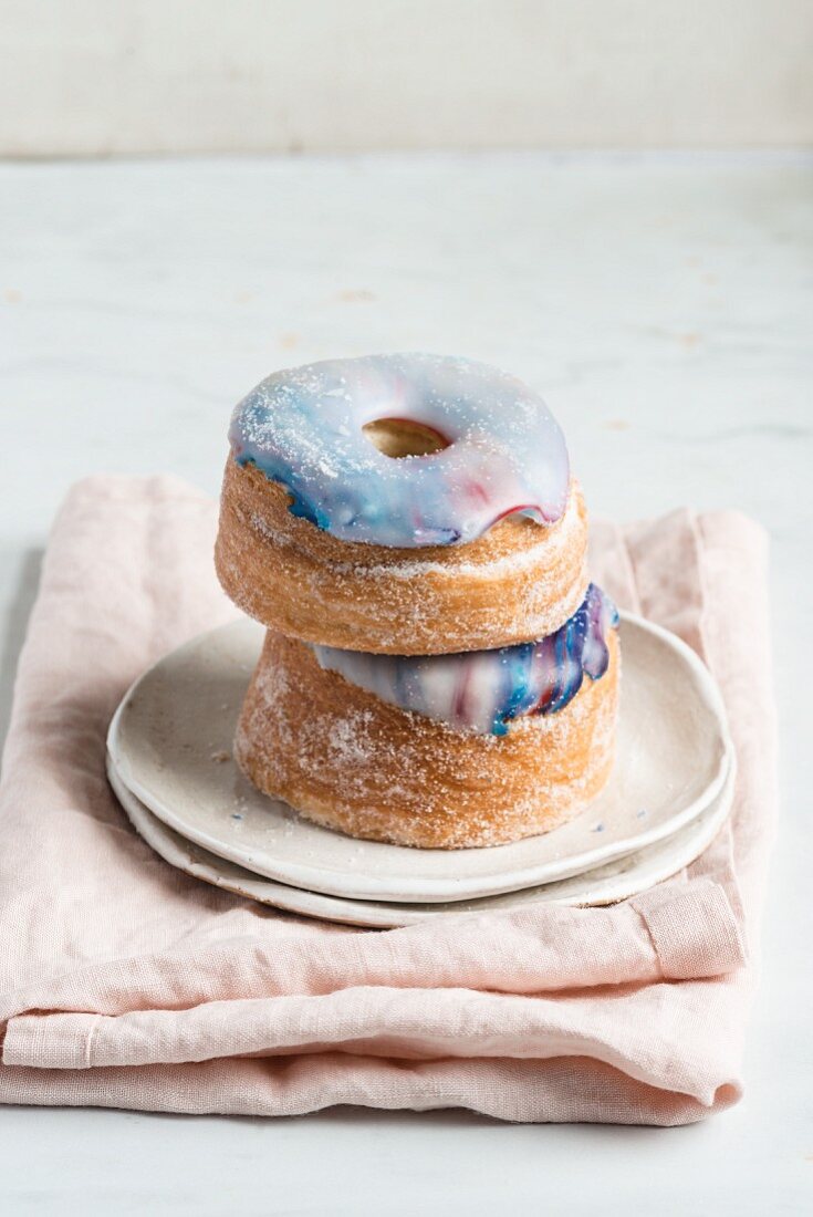 Zwei Galaxie-Croissant-Donuts mit Marmorglasur, gestapelt