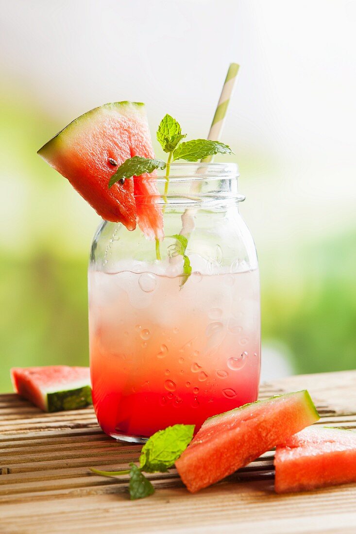 Frischer Wassermelonensaft im Glas mit Eis auf Picknicktisch