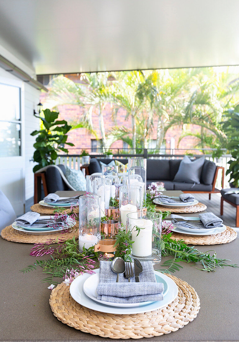 A table laid with table sets and lanterns on the terrace