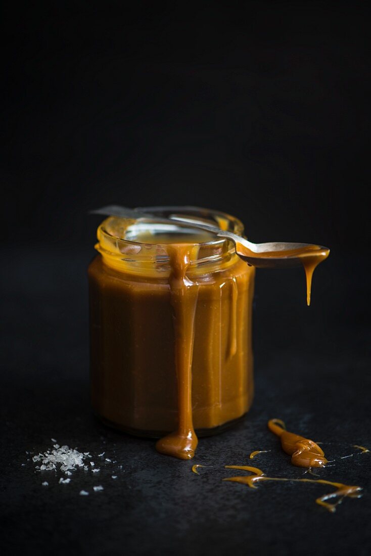 A jar of salted carmel with a spoon